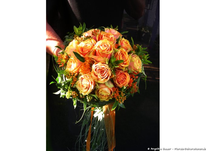 Rund gebundener Brautstrauß in orange-apricot mit Rosen.