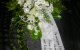 großes Blumengesteck in weiß mit Lilien, Rosen, Chrysanthemen und luftigem Schleierkraut